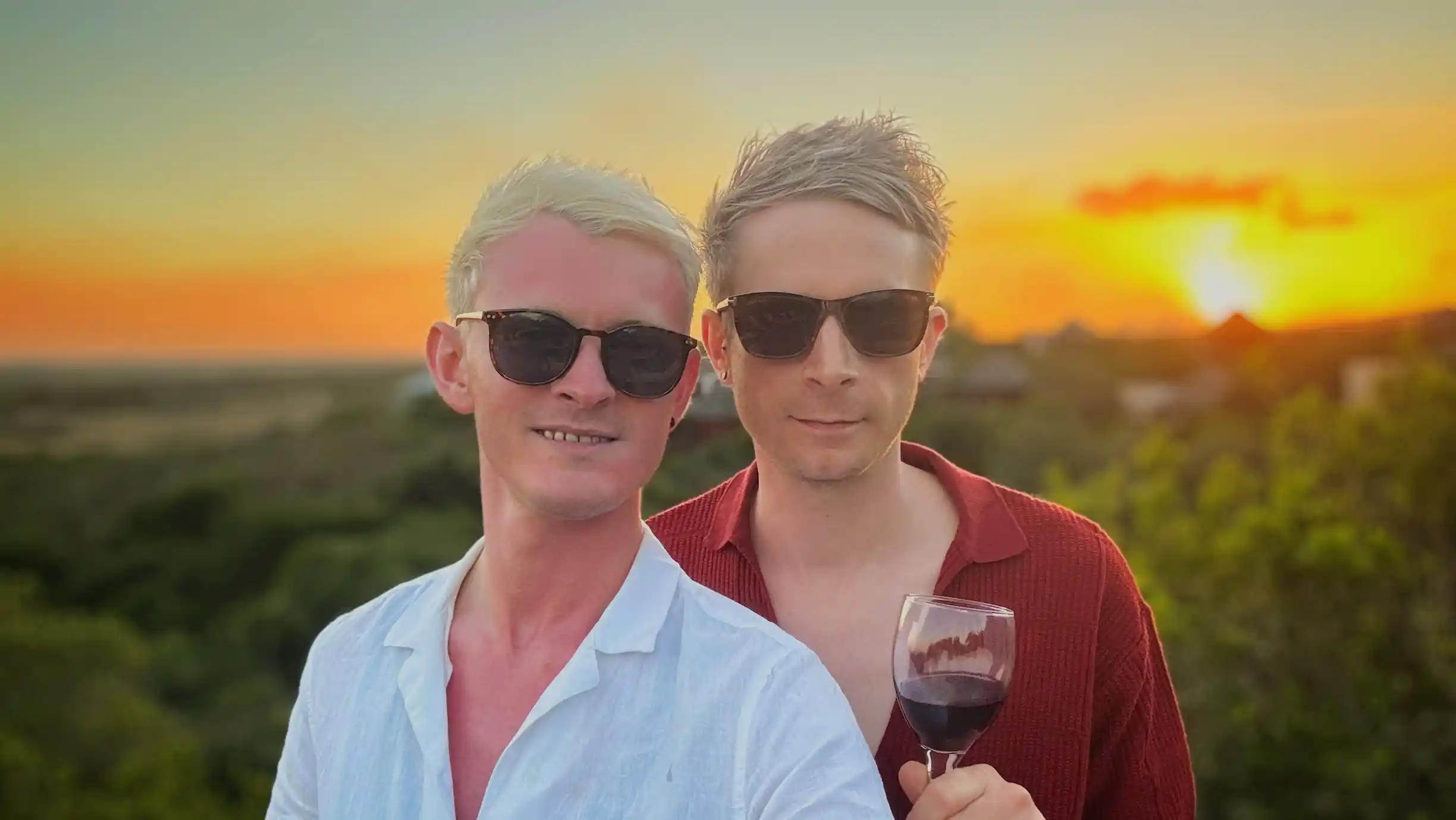 Joe and Alex drinking wine on the deck of a safari lodge along South Africa's Garden Route at sunset
